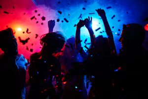 Silhouettes of dancers moving in confetti