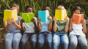 Children sat on a park bench reading #WorldKidLit